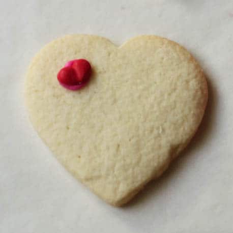 Gluten-free sugar cookie hearts frosted with small icing heart.