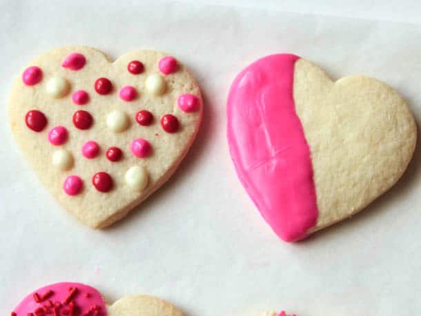 Polka dot decorated gluten-free sugar cookie. Second cookie is half dipped in pink chocolate.