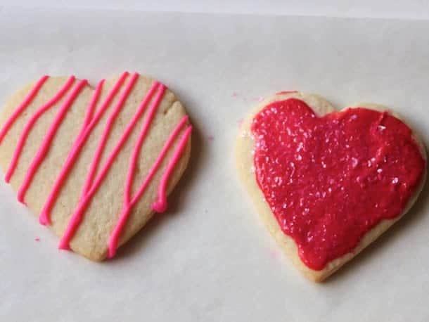 Gluten-free sugar cookie hearts frosted with red frosting.