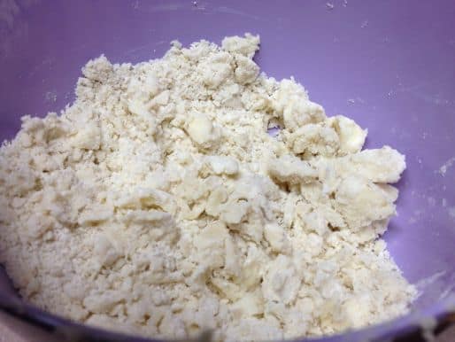 Gluten-free pie crust dough in a purple bowl.