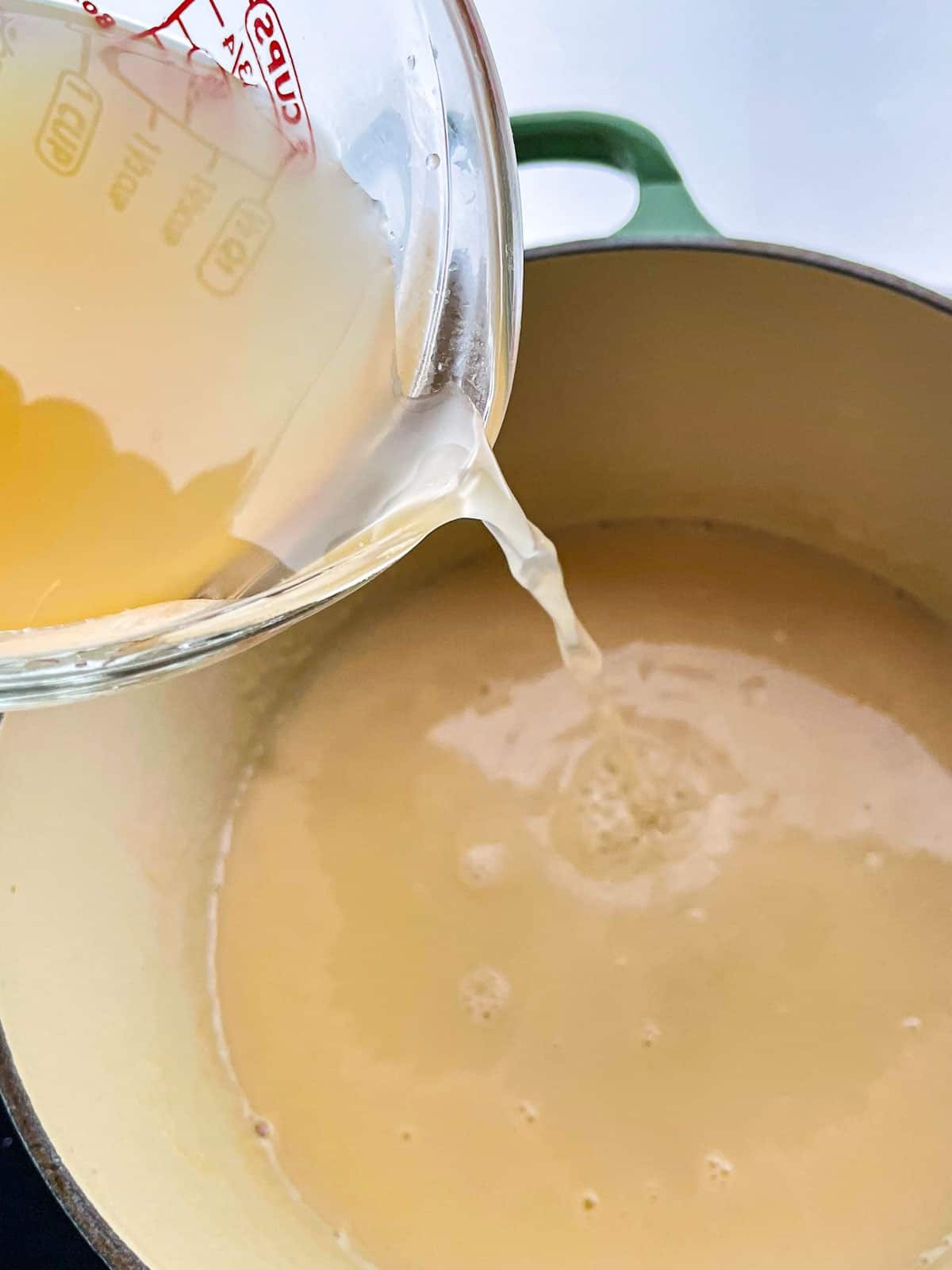 Adding broth to gluten-free gravy.