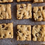 Gluten-Free chocolate chip cookie bars cut on parchment paper.