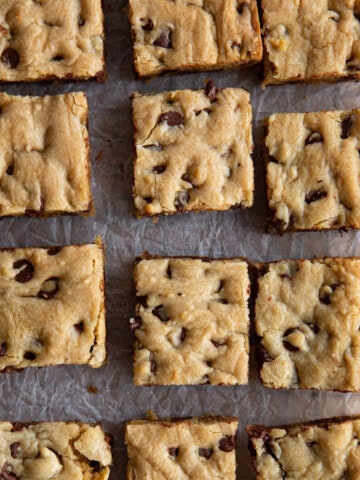 Gluten-Free chocolate chip cookie bars cut on parchment paper.