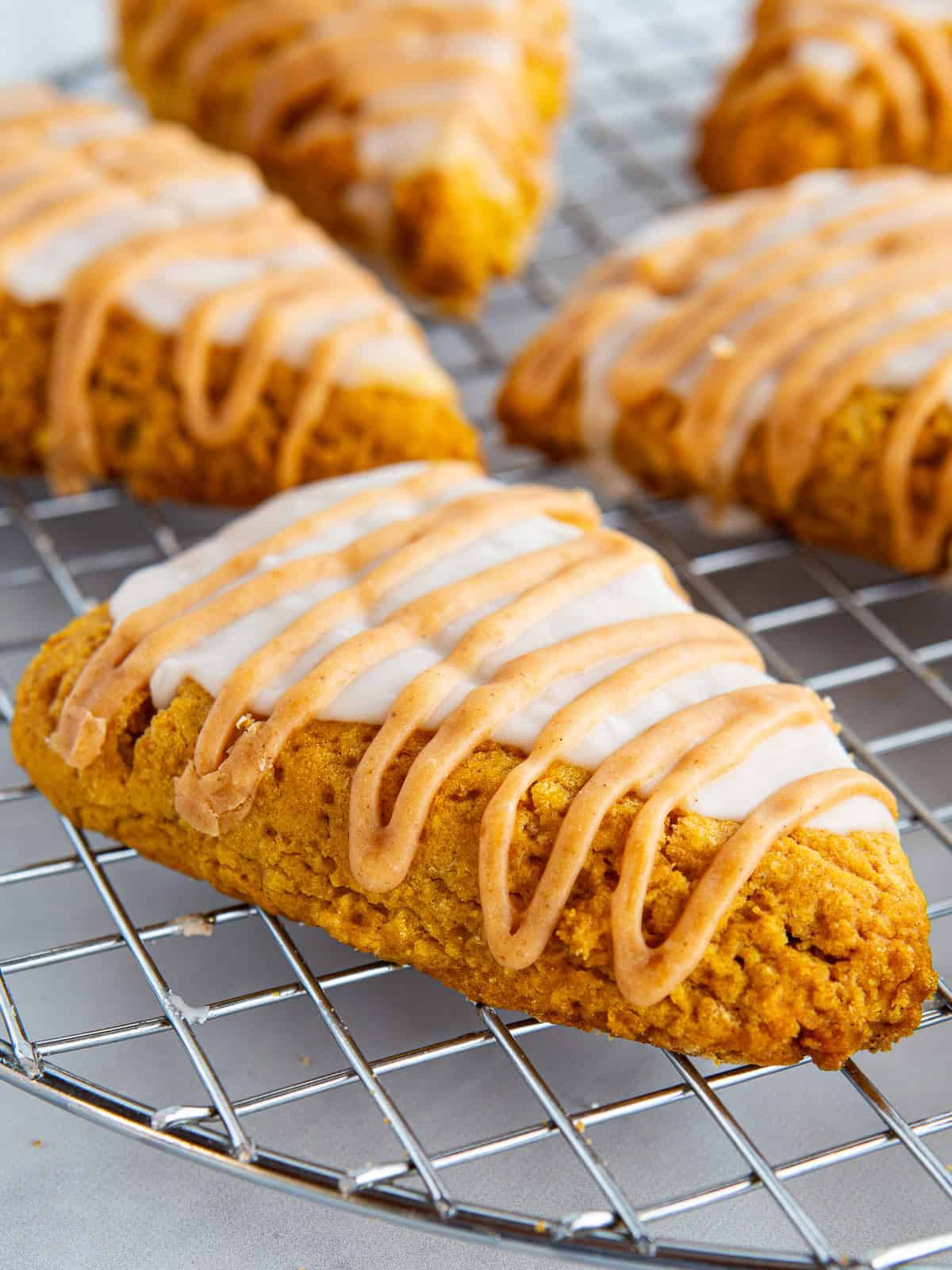 Gluten-free pumpkin scone glazed on a wire rack.